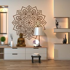 a buddha statue sitting on top of a wooden table in front of a white wall