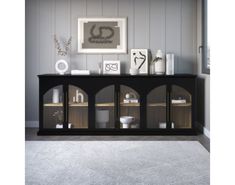 a living room with white carpeting and a black entertainment center