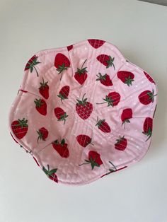 a paper plate with strawberries on it sitting on a white counter top next to a wall