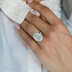 a woman's hand with a diamond ring on her left wrist and a white bowtie around her neck