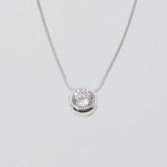 "After many requests for this Celebrity Style necklace, I present to you my fabulous Cubic Zirconia Solitaire Necklace. This 1 carat CZ is high quality and super flashy and sparkly. Wear with jeans or to a formal occasion! Details: 1) 8mm Sterling Silver bezel, set with a 7mm sparkly Cubic Zirconia, (a little over 1 carat). The thickness of the bezel is 5mm. 2) 1mm 16\" Sterling Silver snake chain 3) Sterling Silver lobster clasp 4) Theresa Mink signature tag - in sterling silver. This 1 carat C Cubic Zirconia Necklace With Brilliant Round Cut, Cubic Zirconia Necklaces With Prong Setting In Round Shape, Brilliant Cut Cubic Zirconia Pendant Necklace, Round Cut Cubic Zirconia Necklace With Brilliant Cut, Brilliant Cut Round Cubic Zirconia Necklaces, Brilliant Cut Crystal Solitaire Pendant Necklace, Crystal Diamond Necklace With Round Pendant For Anniversary, Classic Rhinestone Necklace With Diamond Accents For Gift, White Gold Round Rhinestone Necklace For Formal