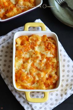 a casserole dish with cheese in it on a polka dot towel next to a pot