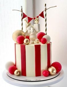 a red and white striped cake with decorations on top