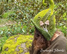 This hand-sculpted hat is made using nearly 1lb of sheep's wool, making it extremely durable and able to hold its shape well, perfect for woodland walks. It is hand dyed in multi-faceted, vibrant, and luminous shades of chartreuse and forest greens. It comes adorned with ferns, fiddleheads, and two mushrooms. This piece was inspired, in part, by the beautiful, moss-draped, temperate rain forests of my Pacific Northwest home. I wanted to create a hat that captured, as much as possible, the many colors and shades of vibrant moss that grow here.  The hats are made using the ancient technique of wet felting. They are not knitted or upcycled. The process begins with raw sheep's wool purchased locally from small family farms. It is then washed, dyed, and carded into bats by me before being hand Flower Fairy Hat Tutorial, Felting Flowers, Mushroom Hats, Felted Fairies, Hat Cottagecore, Fairy Hat, Fairycore Clothing, Magic Creatures, Cottagecore Witch