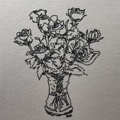 a vase filled with lots of flowers on top of a piece of paper