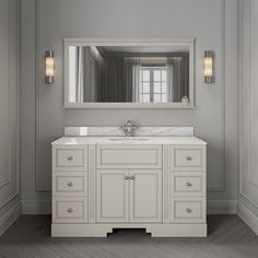 a bathroom vanity with a mirror above it and two lights on the wall next to it