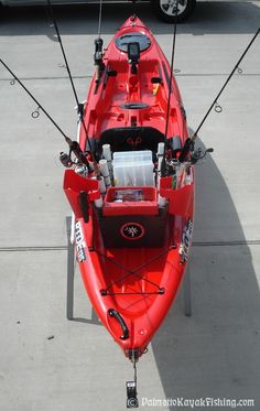 a red kayak sitting on top of a parking lot