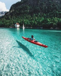 a person in a red kayak on clear water