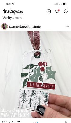 someone holding up a christmas ornament on their left hand and the tag says it's the season