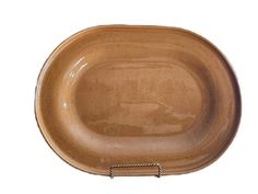 a brown ceramic dish with handles on a white background