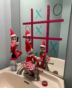 three elfs are sitting in the bathroom sink