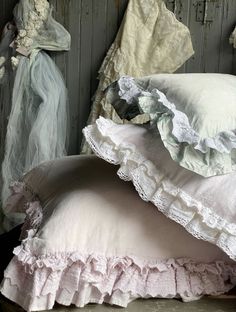 two pillows are stacked on top of each other in front of an old wooden wall