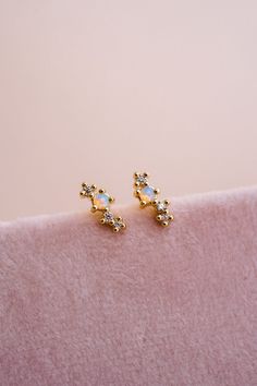 Our Odessa Opal Cluster Studs are out of this world stunning! These dainty studs feature a mesmerizing lab opal stone set in a delicate 14k gold-plated design with sparkling white cubic zirconia accents. These tiny beauties may be small, but are mighty pretty! EARRING FEATURES Material: Brass, Lab Opal Stone Dimensions/Size: 7mm x 2mm, 1.3mm opal Finish: 14k Gold Plating Dainty Gold Earrings With Gemstone Accents, Opal Jewelry With Diamond Accents As A Gift, Delicate Gold Jewelry, Dainty Studs, Bohemian Necklace, Opal Stone, Delicate Earrings, Odessa, Kids Art