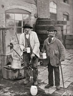 two men standing next to each other holding buckets and cups in their hands,