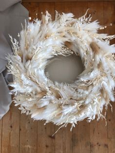 a wreath made out of feathers sitting on top of a wooden floor