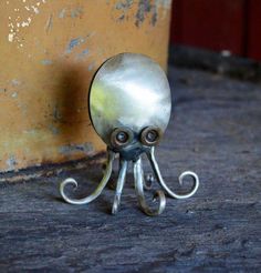 an octopus figurine sitting on the ground next to a yellow wall and door