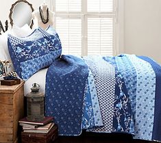 a bed with blue and white quilts on it