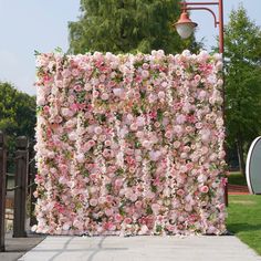 a large pink flowered wall next to a street light