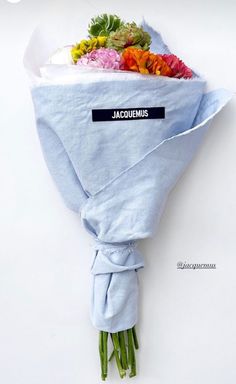 a bunch of flowers that are wrapped in some kind of paper with the name jacumemus on it