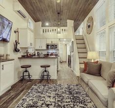 a living room filled with furniture and a flat screen tv mounted to the side of a wall