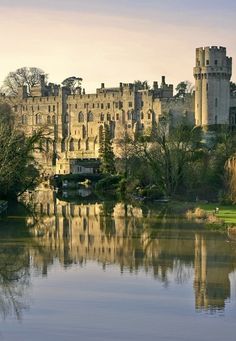 an old castle is reflected in the water