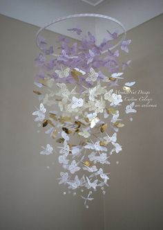 a chandelier with purple and white butterflies hanging from it's center circle