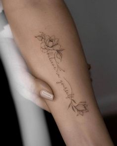 a woman's arm with a flower tattoo on it