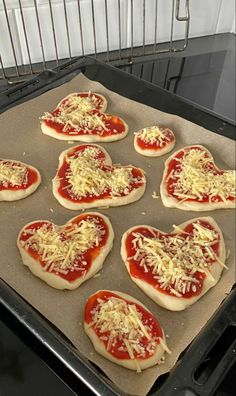 heart shaped pizzas with cheese and tomato sauce in the shape of hearts on an oven tray