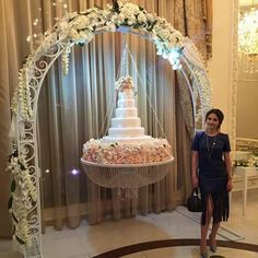 a woman standing in front of a wedding cake