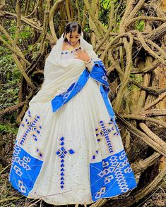 This Habesha Kemis is a true work of art, with its stunning Menen fabric and intricate blue design. The Menen fabric is known for its softness and durability, making this Kemis not only beautiful but also comfortable to wear. The blue design is both striking and delicate, with a pattern that is reminiscent of the intricate designs found in traditional Ethiopian art and textiles. The blue design extends down the front of the Kemis, creating a visually stunning centerpiece that draws the eye and c Ethiopian Art, Eritrean Dress, Ethiopian Clothing, Habesha Dress, Ethiopian Traditional Dress, Ethiopian Dress, Habesha Kemis, Traditional Jewelry, Intricate Designs