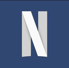 the letter n is cut out of paper and placed on a blue background with white lines