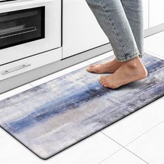 a person standing on a kitchen rug in front of an oven