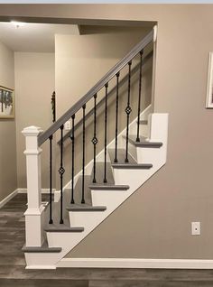 the stairs in this house are painted gray and white with black balconies on each handrail