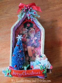 a christmas card holder with santa and his sleigh on the top, surrounded by small trees