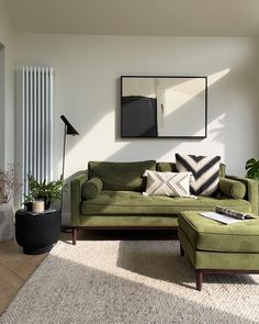 a living room with a green couch and ottoman