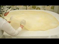 two women making pizza dough on top of a table