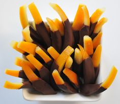 a white bowl filled with orange and brown candy sticks