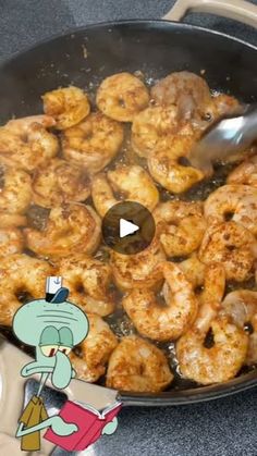 a frying pan filled with shrimp on top of a counter next to a cartoon character