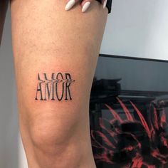 a woman's leg with an arrow tattoo on her left thigh and the word armor written in black ink