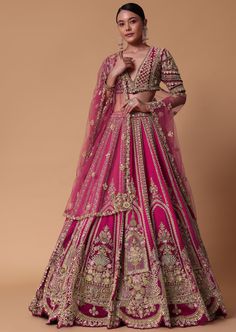 a woman in a pink lehenga with gold embroidery on the chest and sleeves