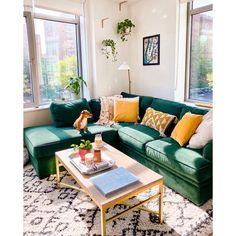 a living room filled with green couches and pillows on top of a white rug