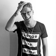 a man wearing glasses and a t - shirt with the words sege de nimes on it