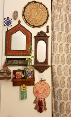 there are many decorative items on the wall above the mirror and shelf in this room