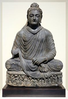 a buddha statue sitting on top of a wooden table