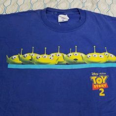 a blue t - shirt with the image of a row of yellow cartoon characters on it