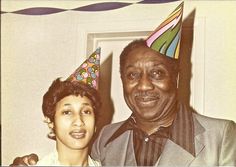 an older man and young woman wearing party hats