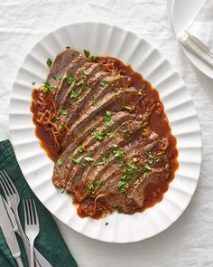 a white plate topped with meat covered in sauce