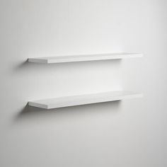 two empty white shelves on the wall