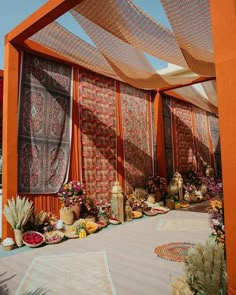 an outdoor area is decorated with many different types of fabrics and rugs on the walls