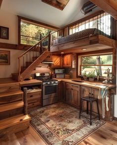 a kitchen with wooden floors and stairs leading up to the second floor